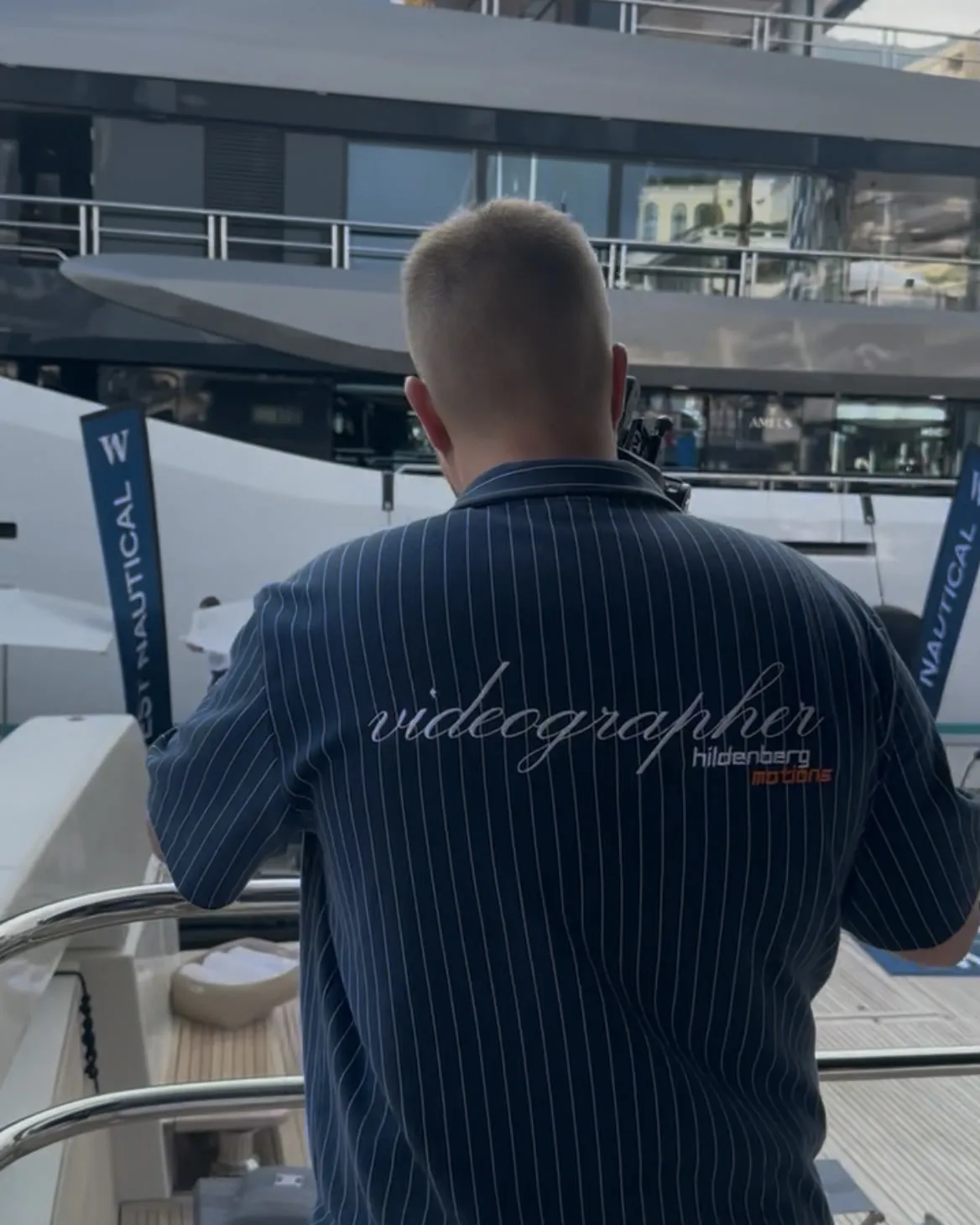 An Deck, auf dem Rücken die Aufschrift „videographer“