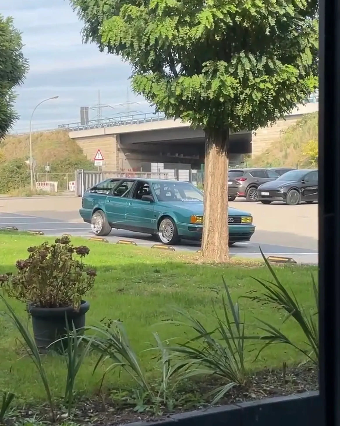 Der Audi rollt über den Parkplatz an seinen Platz, durchs Fenster fotografiert