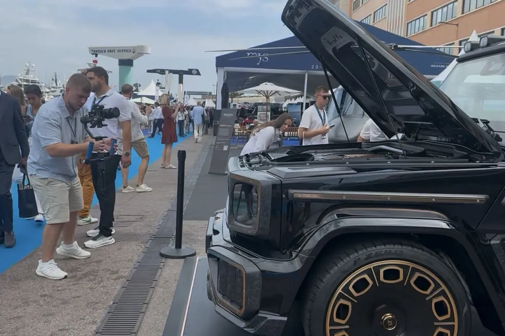 Die G-Klasse mit geöffneter Motorhaube, daneben Besucher der Show