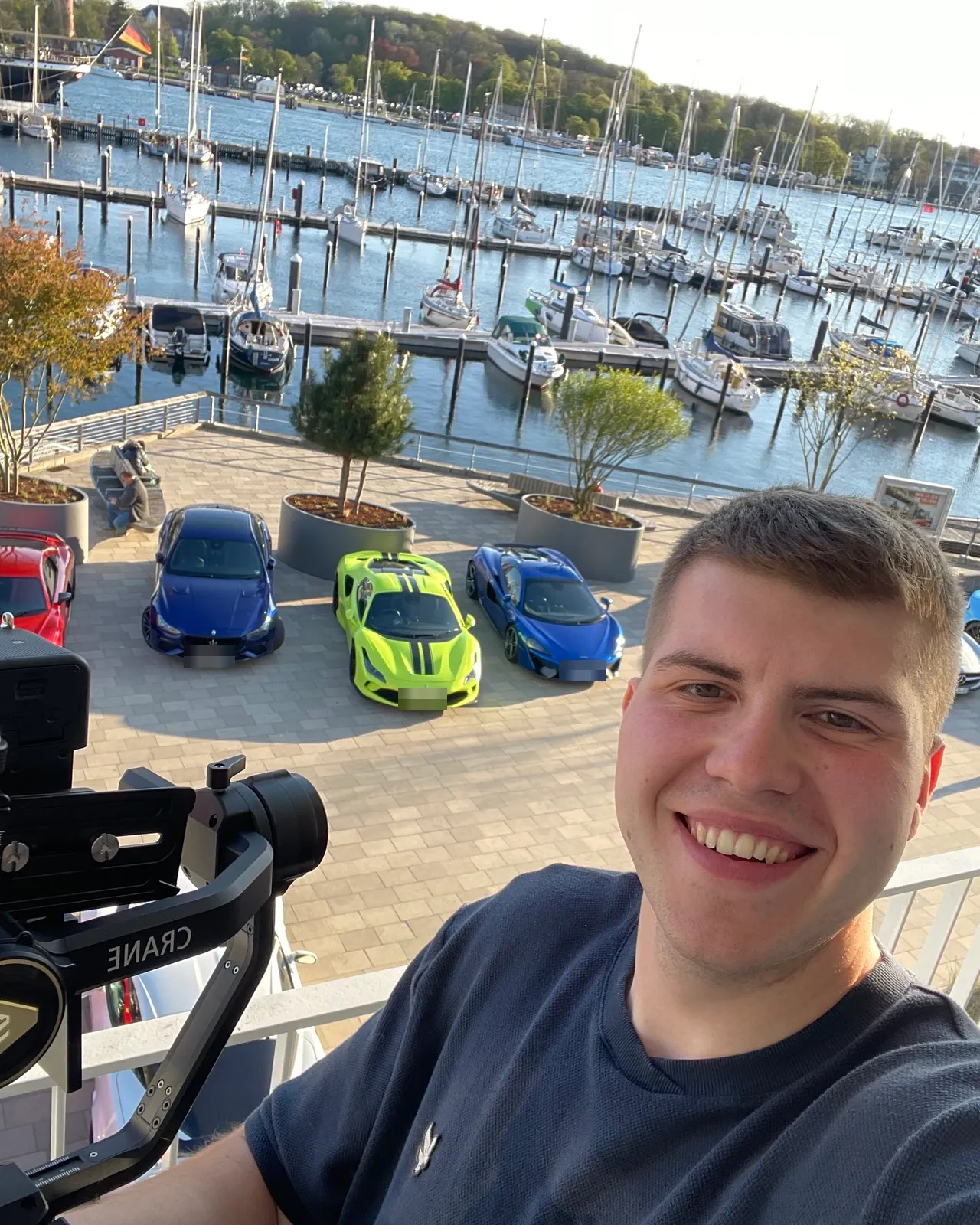 Selfie mit Gimbal über dem Hafen von Travemünde, unten Sportwagen und Segelboote