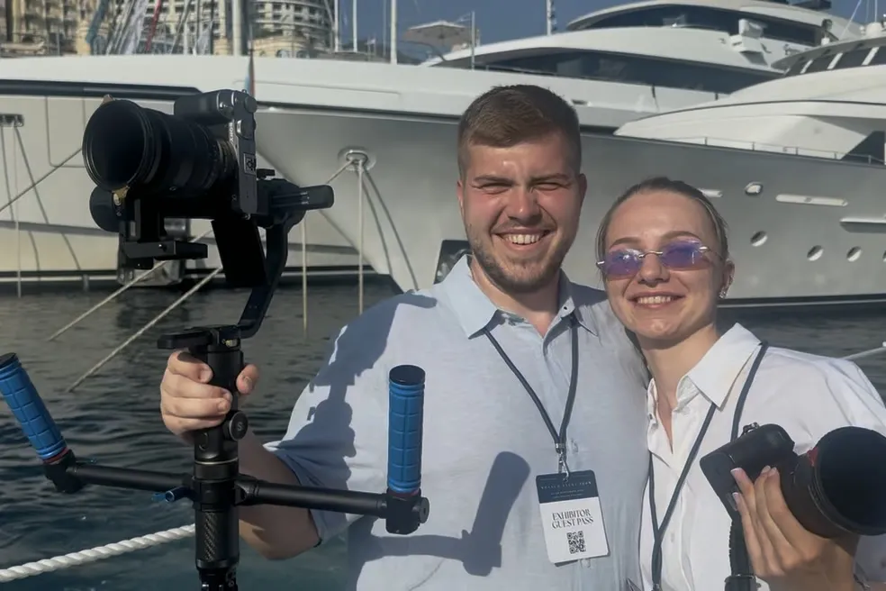 Videograf und Fotografin mit Gimbal und Kamera vor den Yachten