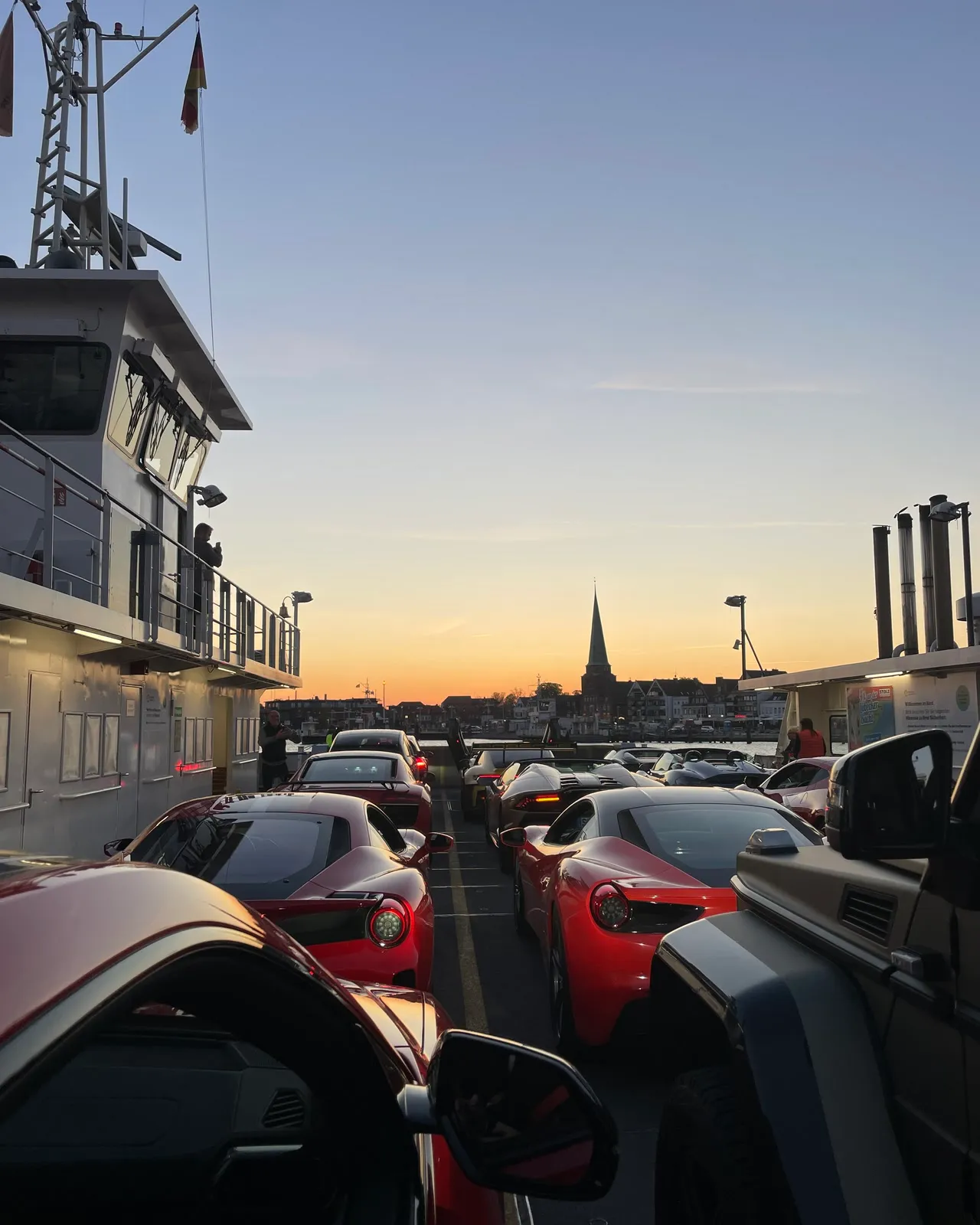 Sportwagen in der Abendsonne, im Hintergrund die Silhouette von Travemünde